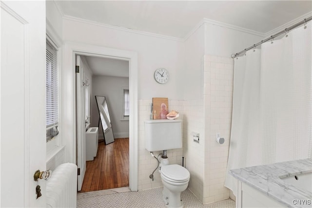 full bathroom featuring tile walls, radiator heating unit, tile patterned floors, and ornamental molding