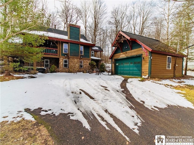 rustic home featuring an outdoor structure, stone siding, a detached garage, and a chimney