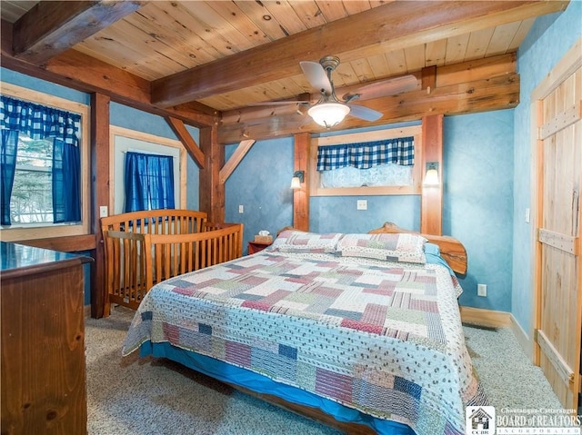 carpeted bedroom featuring beam ceiling, wooden ceiling, and baseboards