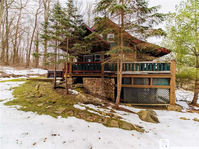 snow covered property with a deck