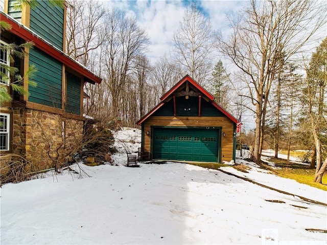 snow covered garage with a detached garage