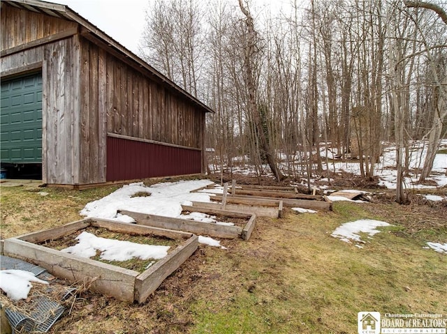 exterior space with a garage and an outbuilding