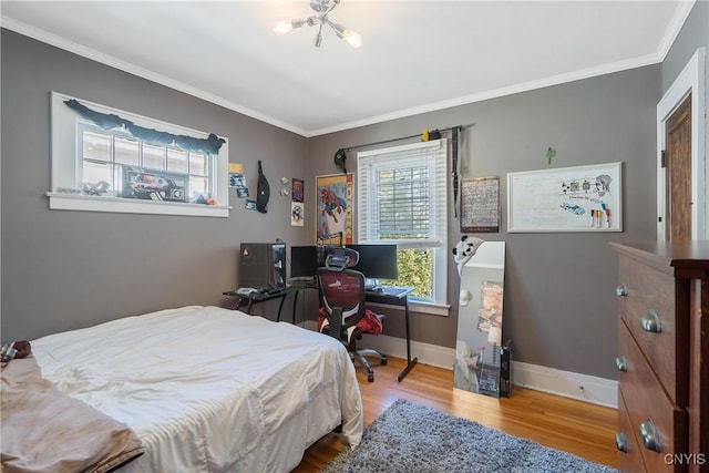 bedroom featuring wood finished floors, baseboards, and ornamental molding