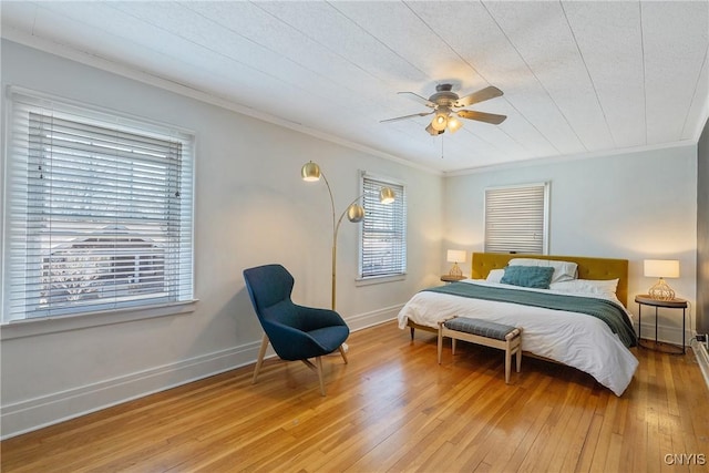 bedroom with crown molding, light wood-style floors, and baseboards