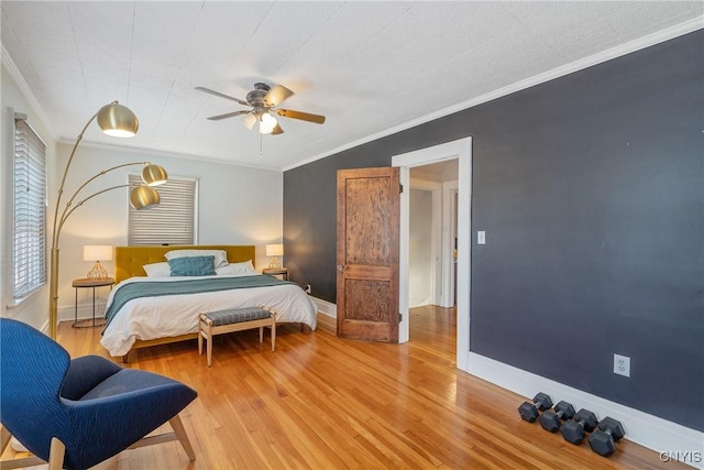 bedroom featuring baseboards, light wood-style flooring, and crown molding