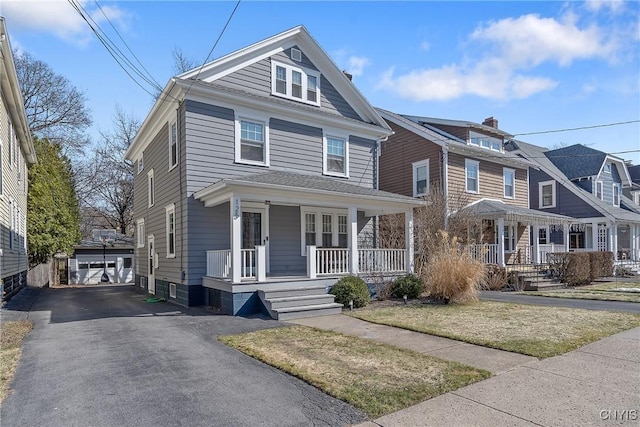 american foursquare style home with aphalt driveway and a porch