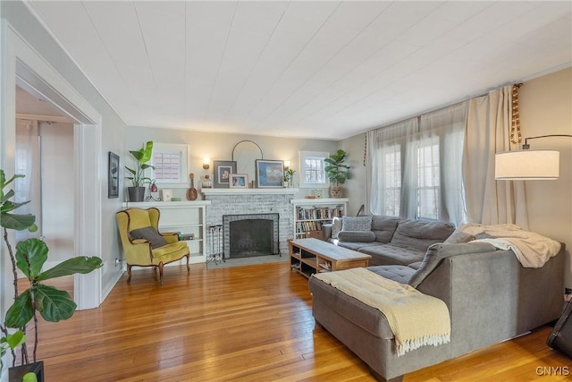 living area featuring light wood finished floors and a brick fireplace