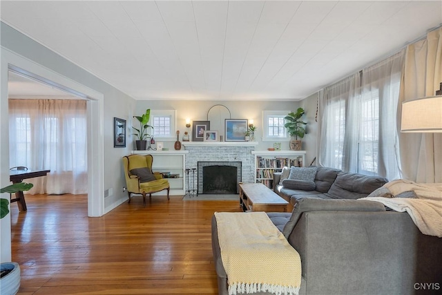 living area featuring a brick fireplace and wood finished floors