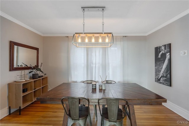 dining area featuring baseboards, wood finished floors, and ornamental molding