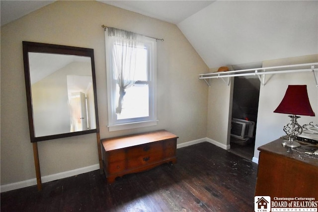 spacious closet featuring wood finished floors, a wall unit AC, and vaulted ceiling