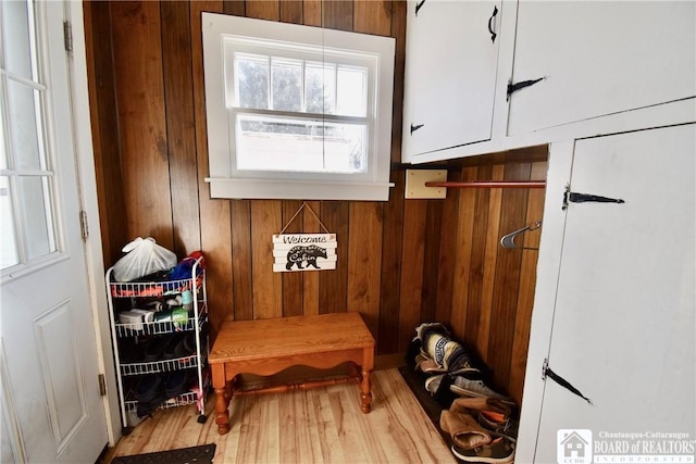 mudroom with wood walls and wood finished floors