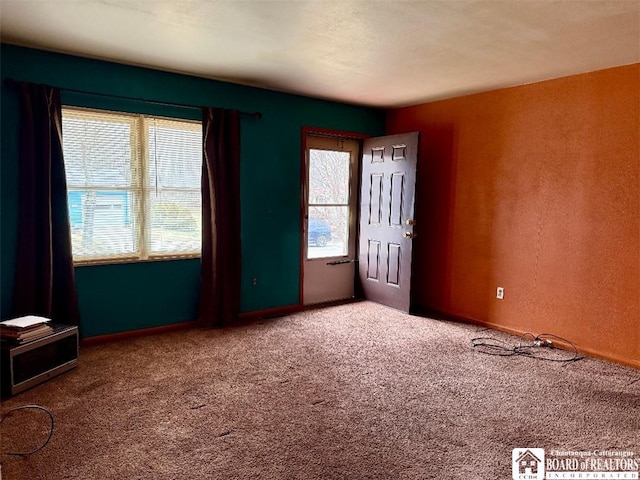 carpeted spare room with a textured wall