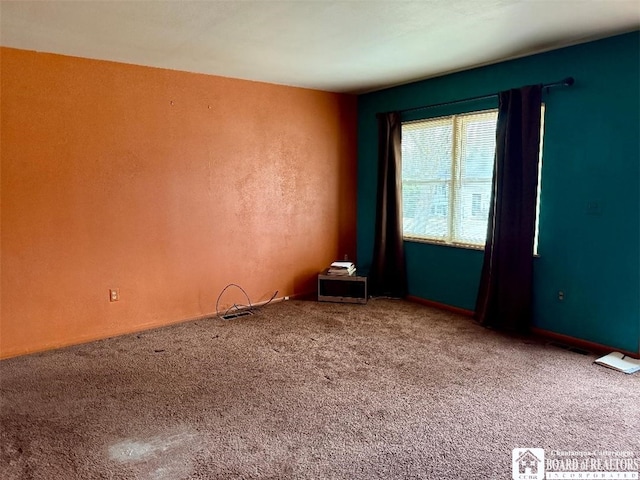 carpeted spare room featuring visible vents