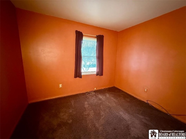 empty room with visible vents and dark carpet