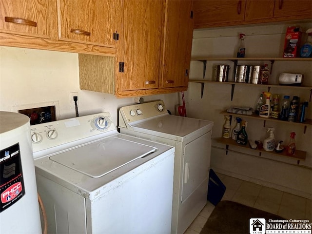 laundry area with washer and clothes dryer, light tile patterned floors, cabinet space, and water heater