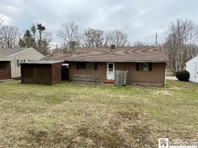 back of house featuring board and batten siding, a chimney, and a yard