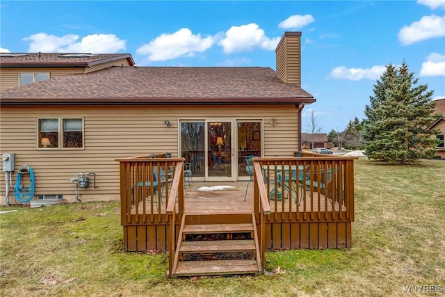 rear view of house with a deck, a yard, a shingled roof, and a chimney