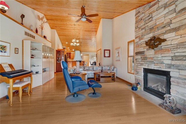 living room featuring a fireplace, light wood-style floors, wood ceiling, and visible vents