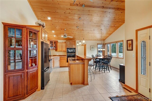 kitchen with light tile patterned floors, black appliances, glass insert cabinets, wood ceiling, and a kitchen bar