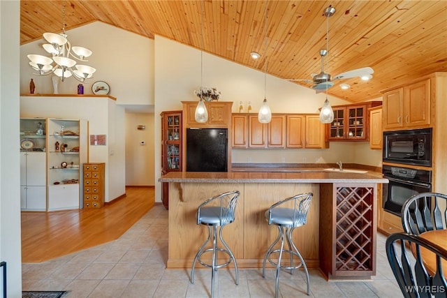 kitchen with black appliances, a kitchen island with sink, wooden ceiling, light tile patterned floors, and glass insert cabinets