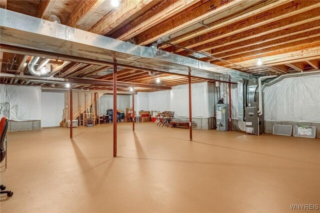 unfinished basement featuring gas water heater and heating unit