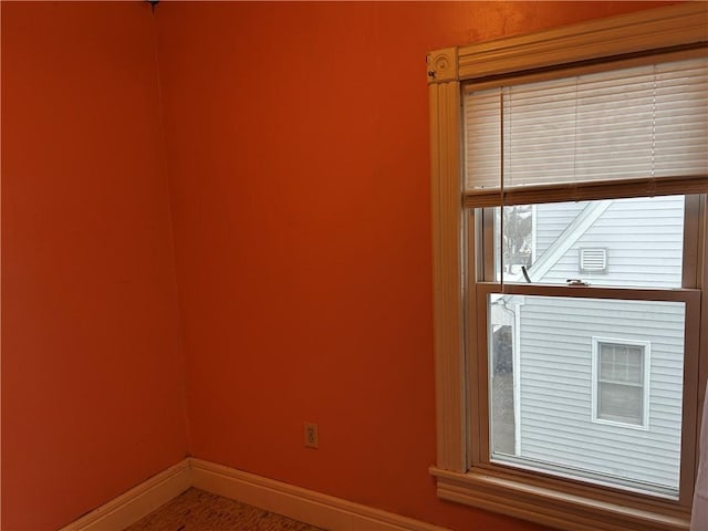 unfurnished room with baseboards