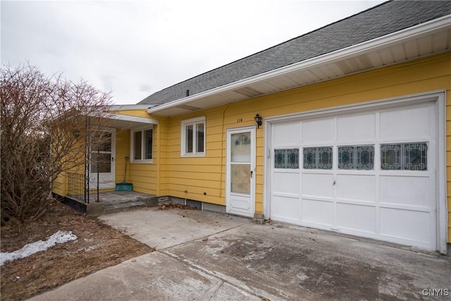 exterior space featuring driveway and a shingled roof