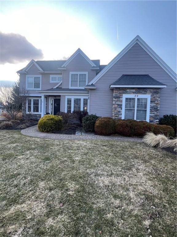 view of front of property featuring stone siding and a front yard