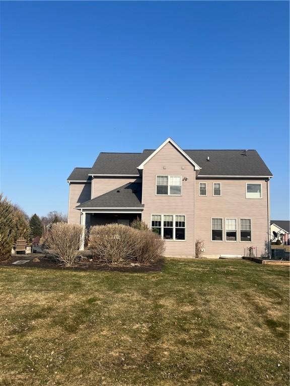 rear view of house featuring a yard