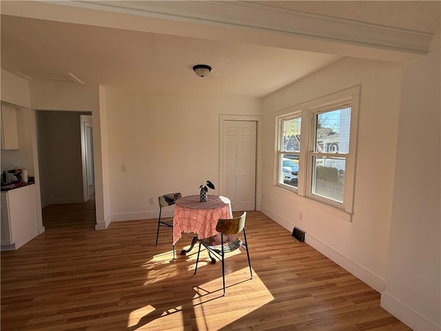 dining area featuring baseboards and light wood-style flooring