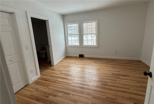 unfurnished bedroom with baseboards and light wood-style floors