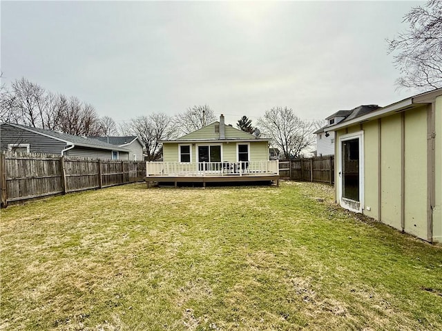 rear view of property featuring a yard, a fenced backyard, and a wooden deck