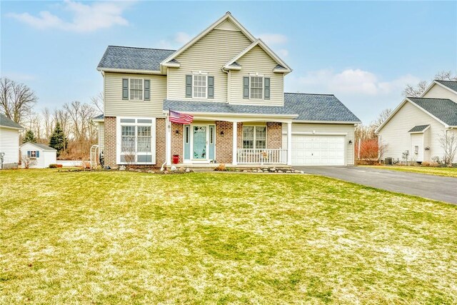 traditional-style home featuring aphalt driveway, a front lawn, brick siding, and an attached garage