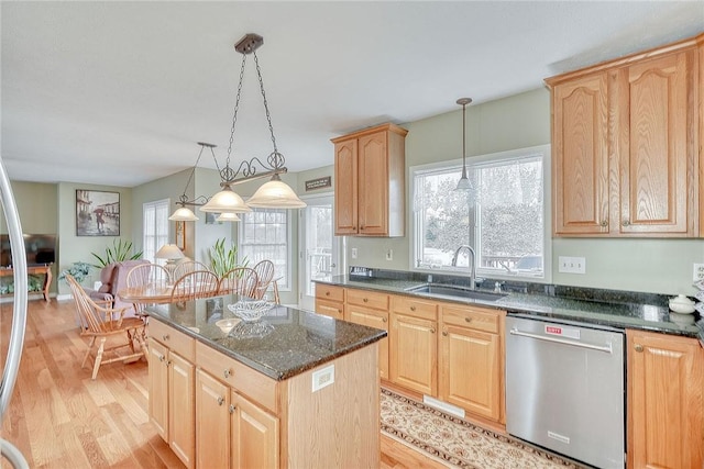 kitchen featuring light brown cabinetry, a sink, light wood-type flooring, and stainless steel dishwasher