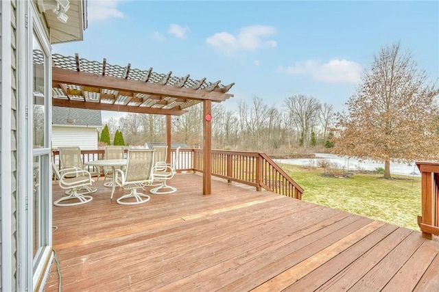 deck featuring outdoor dining space, a yard, a pergola, and a water view