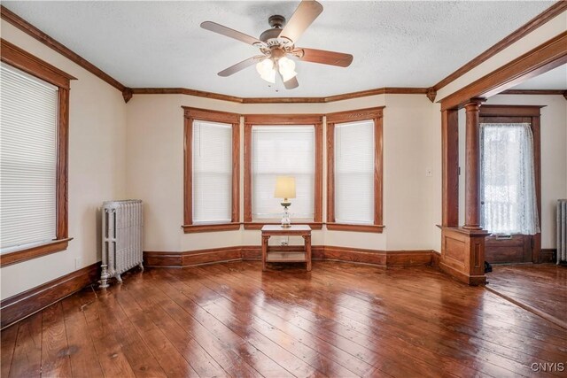 unfurnished room featuring hardwood / wood-style flooring, radiator heating unit, and a textured ceiling