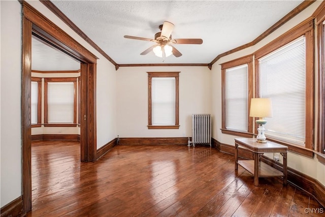 interior space featuring ornamental molding, a textured ceiling, radiator heating unit, and hardwood / wood-style floors