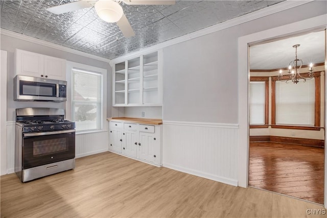 kitchen with crown molding, light wood-type flooring, an ornate ceiling, stainless steel appliances, and open shelves