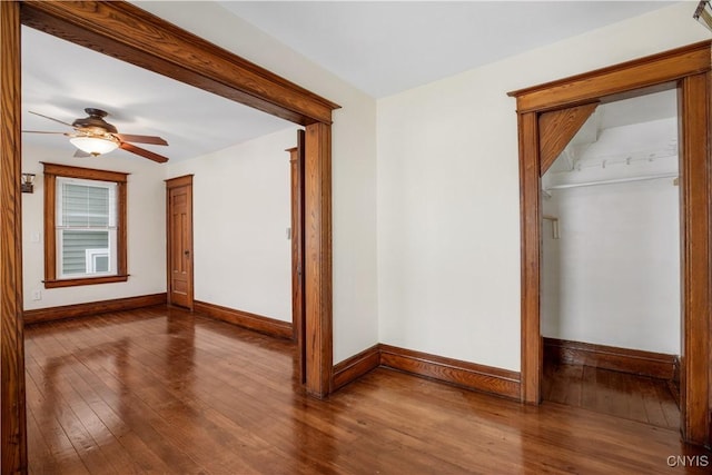 spare room with ceiling fan, baseboards, and hardwood / wood-style flooring