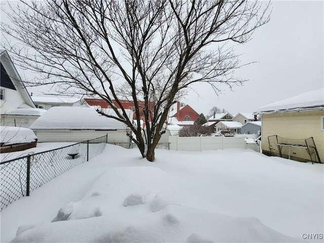 snowy yard with a residential view and a fenced backyard