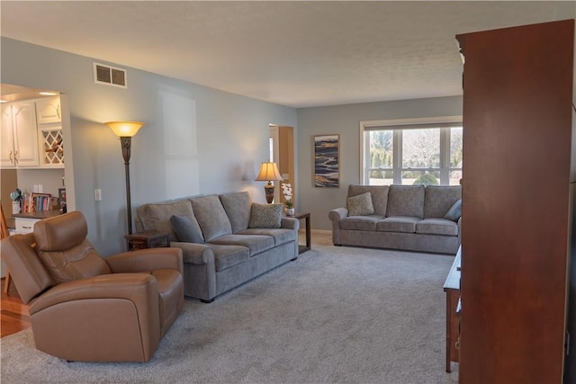 carpeted living area featuring visible vents