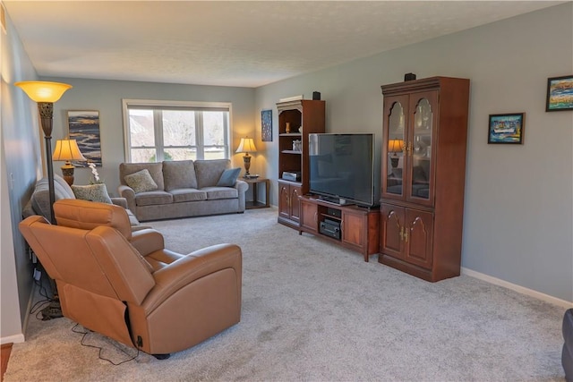 living area with baseboards and light colored carpet