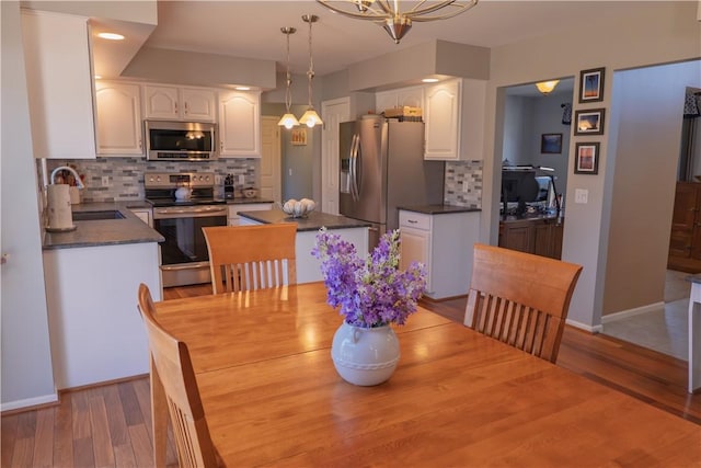 dining space with baseboards and light wood-style floors