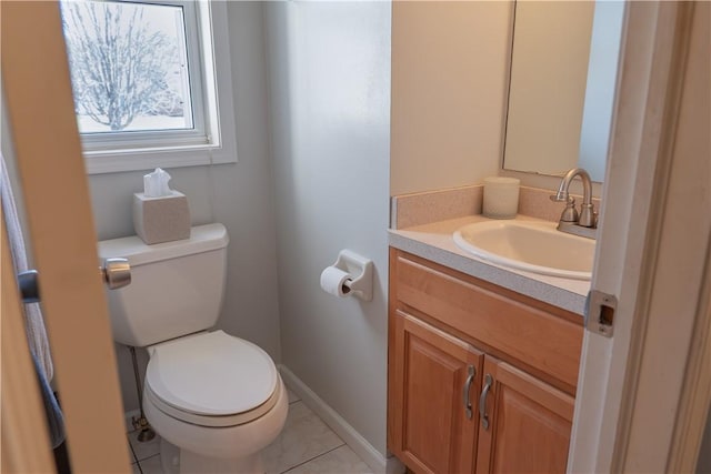 half bathroom with vanity, toilet, baseboards, and tile patterned flooring