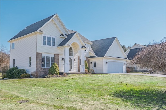 view of front of house with a front yard, a garage, and brick siding