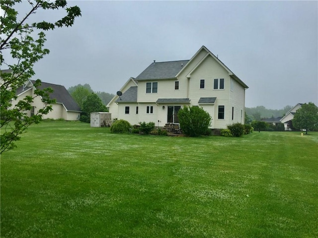 rear view of house featuring a lawn