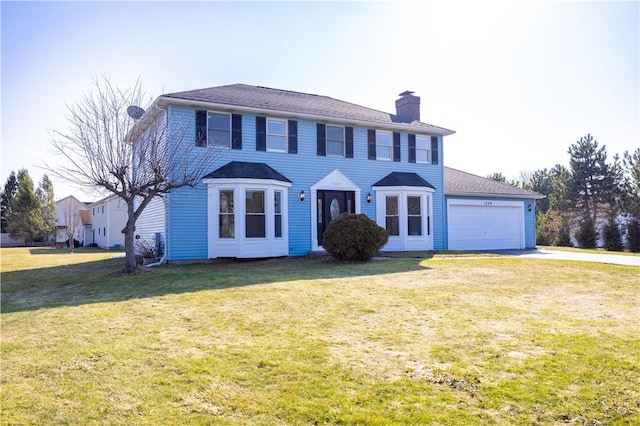 colonial-style house featuring a front yard, an attached garage, and a chimney