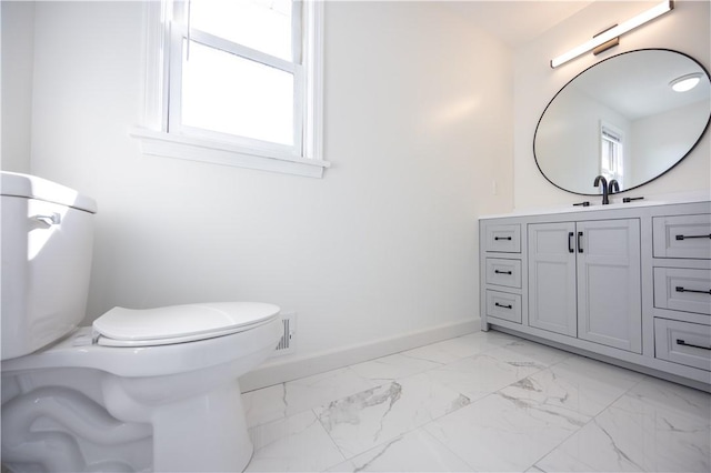 bathroom featuring vanity, toilet, baseboards, and marble finish floor