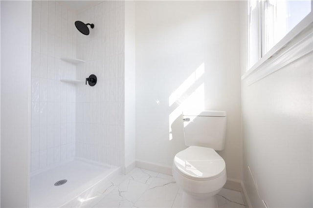 bathroom with toilet, marble finish floor, and a stall shower