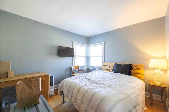 bedroom with light wood-type flooring and baseboards